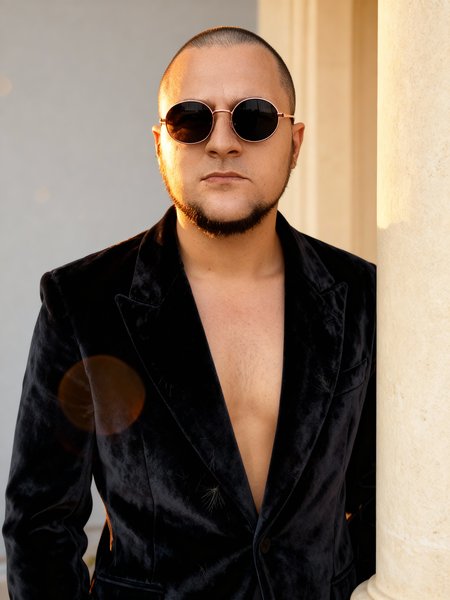 Man in round sunglasses and velvet blazer